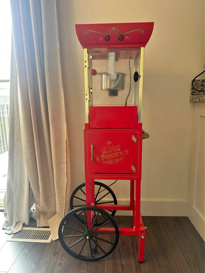 Red vintage-style popcorn machine on a cart